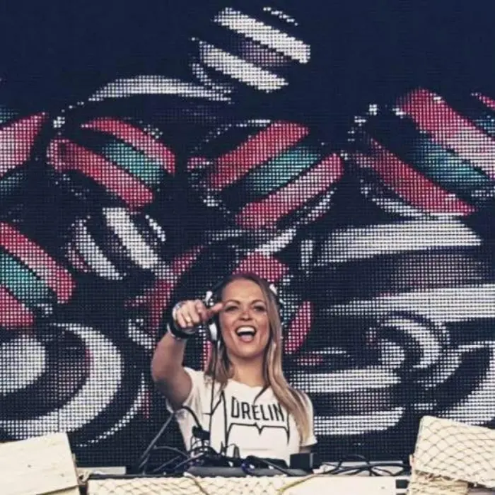 Adrelina laughing on the mic in front of an LED wall